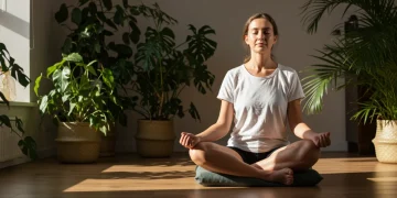 Person meditating peacefully in a calm, modern setting with natural light, embodying daily mindfulness